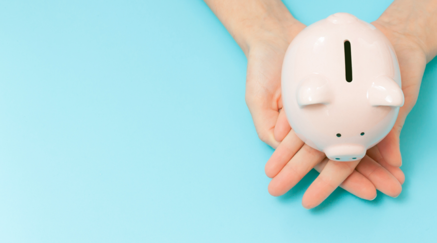 white piggy bank being held in hands on blue background